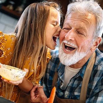 Child and grandfather laughing together after visiting the dentist