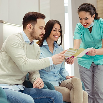 Team member showing patients dental insurance forms