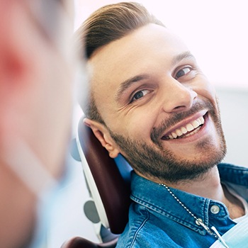 Man in dental chair smiling at provider