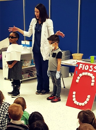 Dentist giving oral health presentation to young people