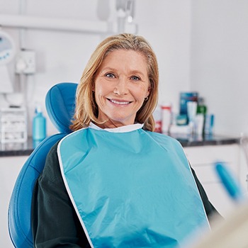 Female patient sitting in dental chair and smiling