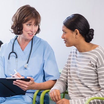 Dentist and patient reviewing dental insurance forms