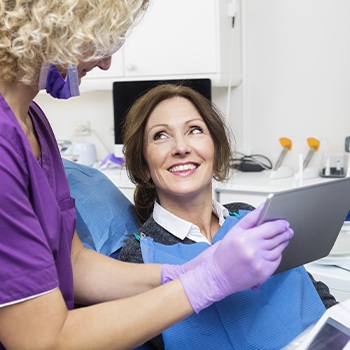 Woman discussing Invisalign treatment with dental team member
