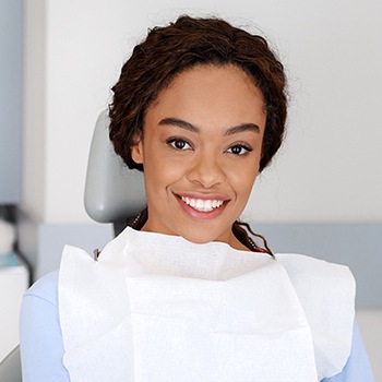 Woman in dental chair for preventive dentistry smiling together