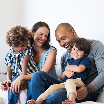 Mother father rand two children smiling together after family dentistry