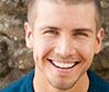 Man smiling outdoors after restorative dentistry