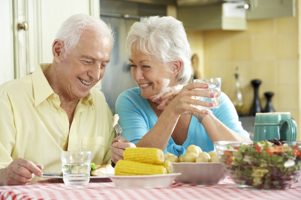 People smiling and enjoying food.