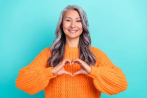 Smiling woman making heart shape with her hands